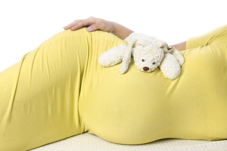 Happy pregnant girl lies on white backgroundの写真素材