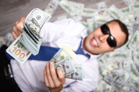 Happy guy with money in his hands for the development of shopping business and a great tripの写真素材