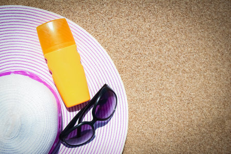 Stylish beautiful hat with cream on the seashore backgroundの写真素材