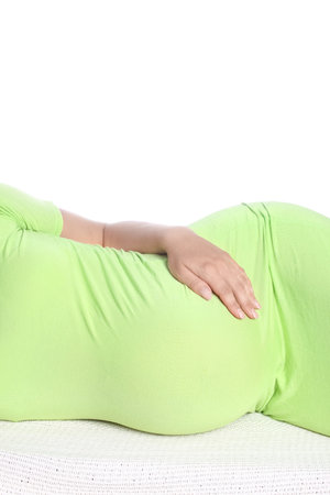 Happy pregnant girl lies on white backgroundの写真素材