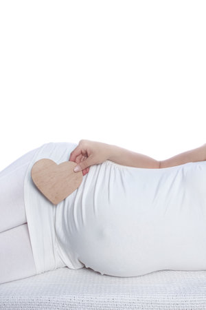 Happy pregnant girl lies on white backgroundの写真素材