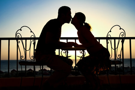 Beautiful couple silhouette on nature near the sea on a rift backgroundの写真素材