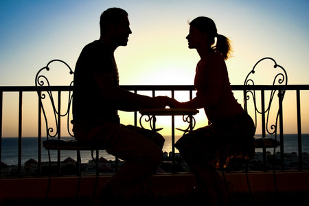 Beautiful couple silhouette on nature near the sea on a rift backgroundの写真素材