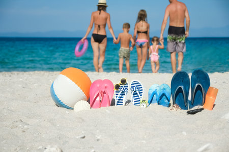happy family on the sea with slippers on nature backgroundの写真素材