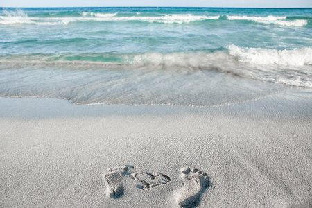 beautiful footprints in the sand near the sea on nature backgroundの写真素材