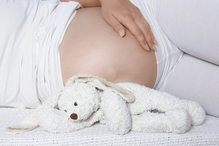 Happy pregnant girl lies on white backgroundの写真素材