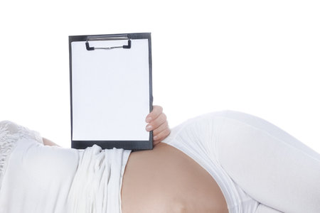 Happy pregnant girl lies on white backgroundの写真素材