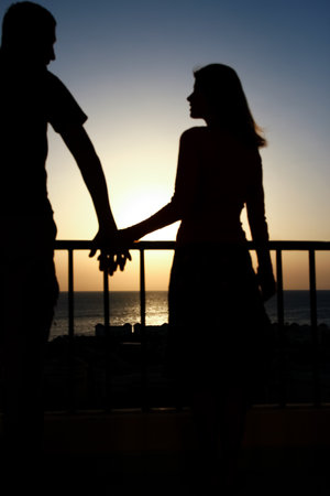 Beautiful couple silhouette on nature near the sea on a rift backgroundの写真素材