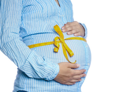 Happy pregnant girl lies on white backgroundの写真素材