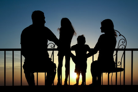 Happy family at the dawn of the sea silhouette backgroundの写真素材