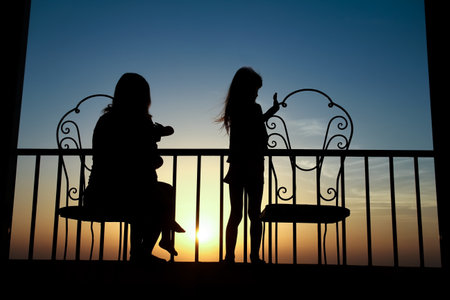 Happy parent with baby at dawn silhouette nature backgroundの写真素材