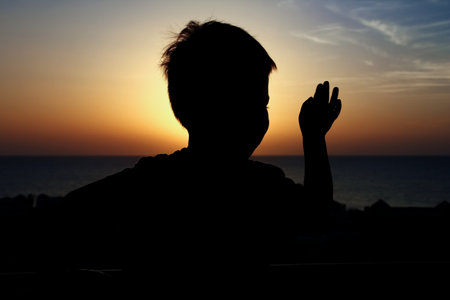 Happy child at the time of the silhouette of the sea backgroundの写真素材