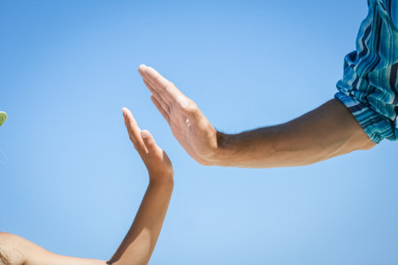 Hands of a happy parent and child on the seashore on a journey trip in natureの写真素材