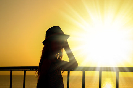 Happy child in hat silhouette on sea backgroundの写真素材