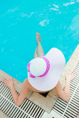 A blower with a hat lies in a relaxation pool. On a journey
woman resting in water background.の写真素材