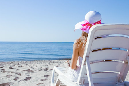happy girl in a chaise lounge on the sea in the summer on the natureの写真素材