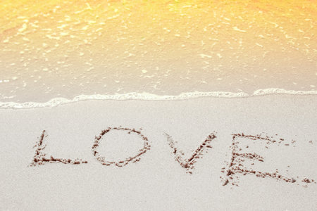 beautiful drawings inscription on the sand of the sea in the summer on the natureの写真素材