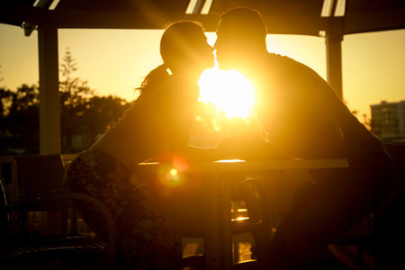 happy couple at a table by the sea at sunset natureの写真素材