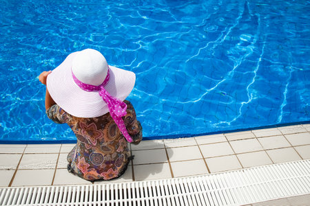 happy girl in a hat by the poolの写真素材