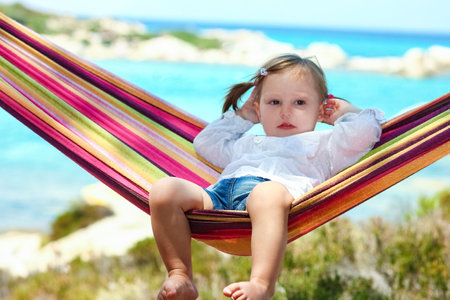 happy child by the sea on hammock in greece backgroundの写真素材