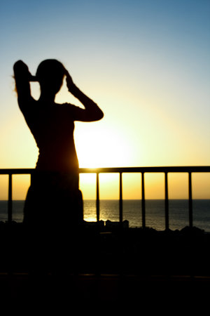 Beautiful girl at the time of the sea silhouette backgroundの写真素材