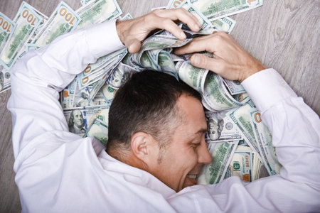 Happy guy with money in his hands for the development of shopping business and a great tripの写真素材