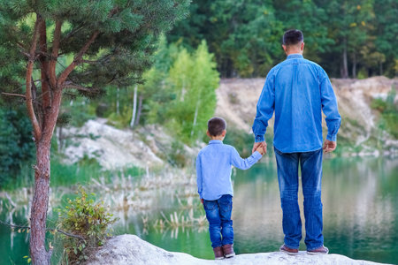 Happy parent with child on nature in park travelの写真素材