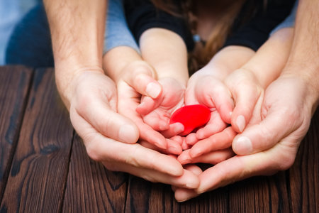 Heart in hands on valentine's day on a wooden background holidayの写真素材