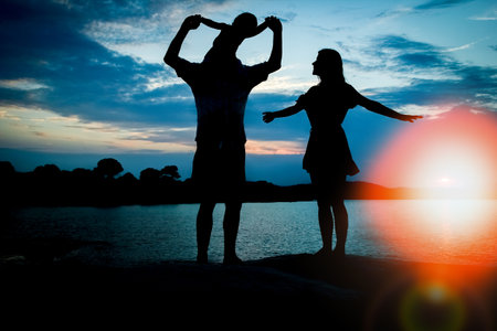 happy family by the sea on nature silhouette backgroundの写真素材