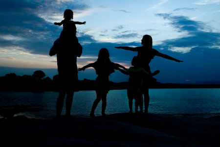 happy family by the sea on nature silhouette backgroundの写真素材