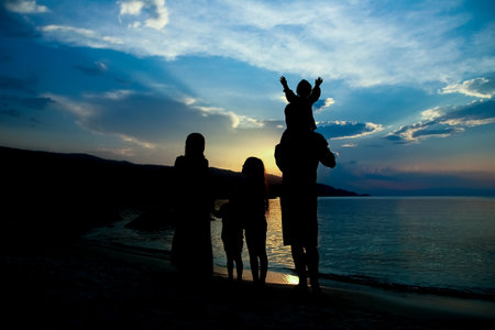happy family silhouette at greek sea backgroundの写真素材