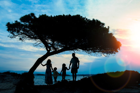 happy family in nature by the sea on a trip silhouetteの写真素材