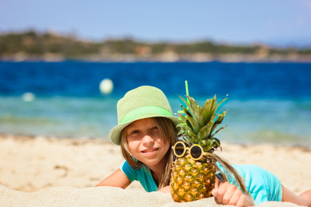 Pineapple in the hands of a man by the sea in nature on a journey backgroundの写真素材