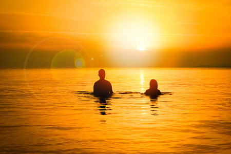 happy couple in the sea on nature travel silhouetteの写真素材