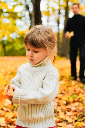 Happy parents with baby on nature in autumn parkの写真素材