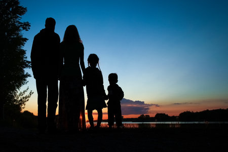 silhouette family, including his father, mother and two children in the hands ofの写真素材