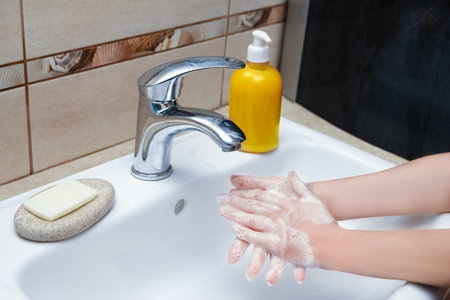 Hands with soap are washed under the tap with water. Clean from infection and dirt and virus. At home or in the hospital ablution office.の写真素材