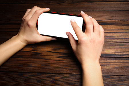 phone with hands on a wooden backgroundの写真素材