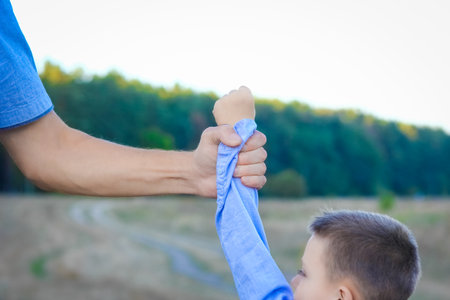 Happy child and parent's hands on nature in the park travelの写真素材