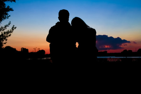 happy couple silhouette against a sunset romanceの写真素材