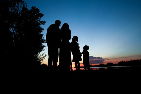 silhouette family, including his father, mother and two children in the hands ofの写真素材