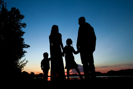silhouette family, including his father, mother and two children in the hands ofの写真素材