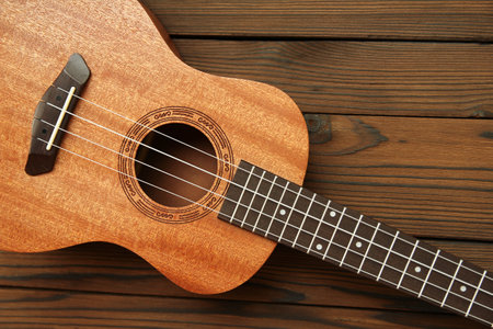 ukulele guitar on brown wooden backgroundの写真素材