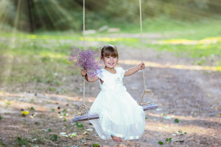 Happy child on a swing in the park on nature recreation travelの写真素材
