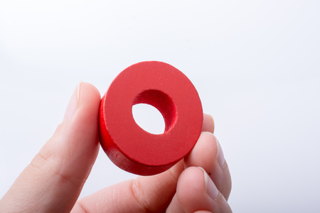 Hand holding letter cube O of made of woodの写真素材