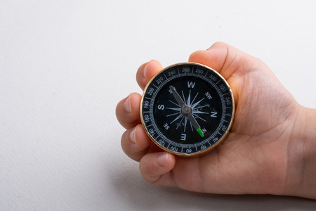 Compass tool in toddler hand on whiteの写真素材