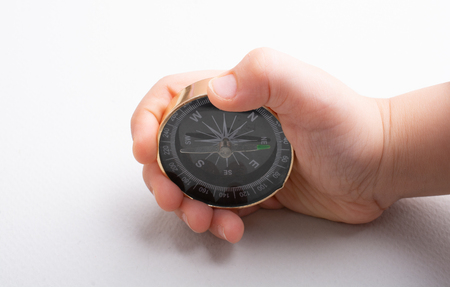 Compass tool in toddler hand on white