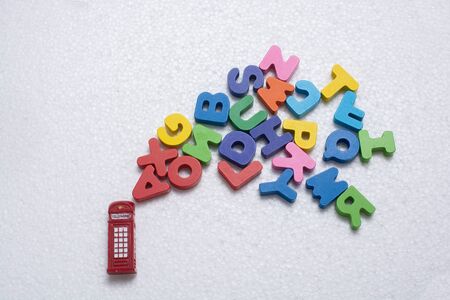 Red telephone booth model and colorful wooden lettersの写真素材