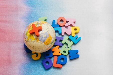 Globe model on colorful letters on a colorful backgroundの写真素材