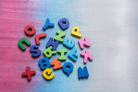 Colorful wooden letters scattered on a white background